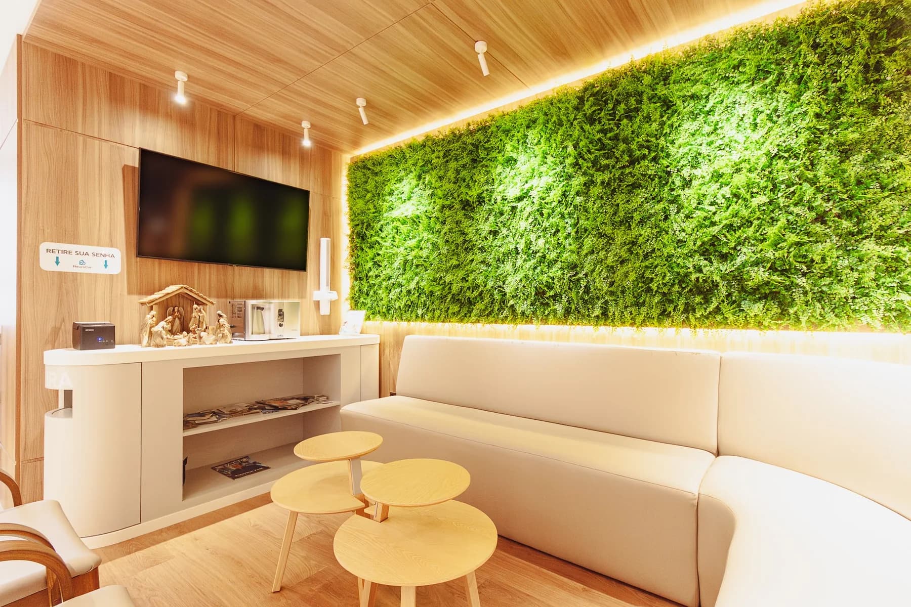 Sala de espera da clínica com parede viva de vegetação